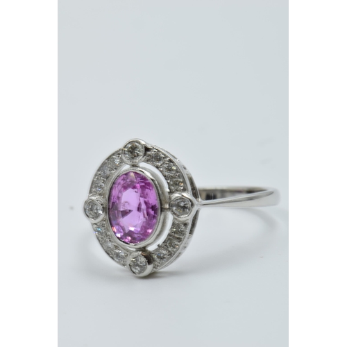 898 - Platinum ring set oval pink sapphire surrounded by brilliant cut diamonds