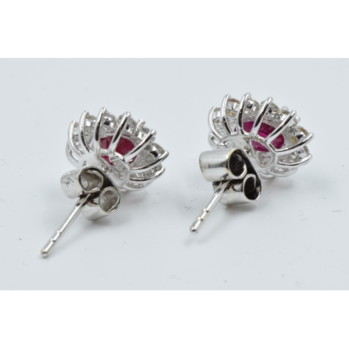 922 - Pair of 18ct white gold oval ruby and diamond cluster ear studs