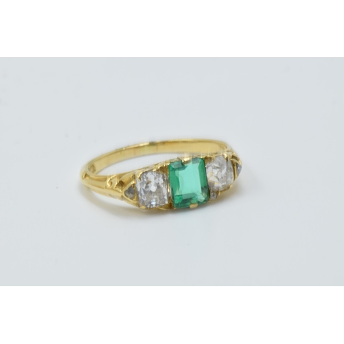 926 - 18ct Yellow gold three stone emerald and diamond ring, the emerald approximately 6mm x 4.5mm, flanke... 