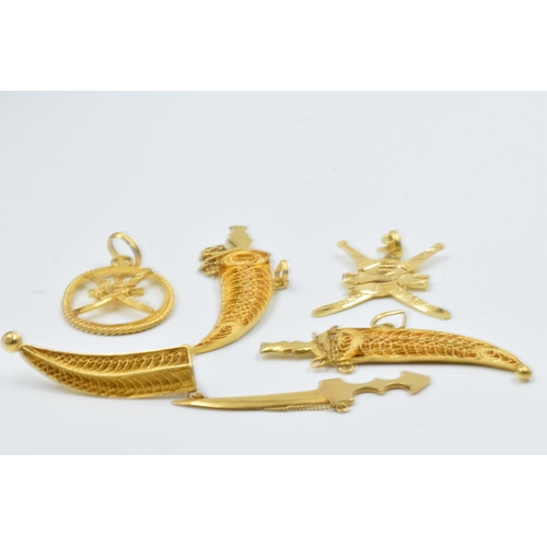 944 - Three Omani yellow metal dagger brooches together with two similar pendants, 22.5g