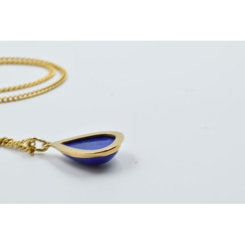 953 - Middle Eastern yellow metal and lapis teardrop pendant on a yellow metal curb link chain, the clasp ... 