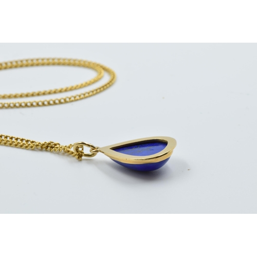 953 - Middle Eastern yellow metal and lapis teardrop pendant on a yellow metal curb link chain, the clasp ... 