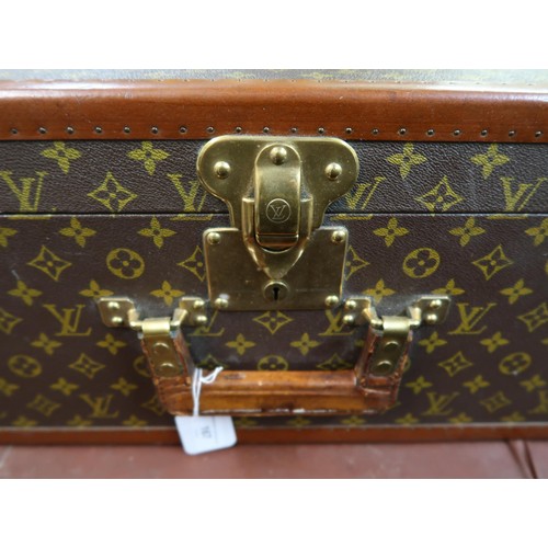 167 - Vintage Louis Vuitton suitcase with brass catches and corner mounts, the hinged lid enclosing a void... 