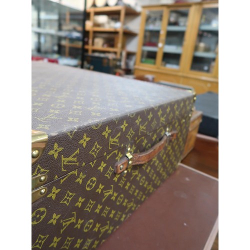 167 - Vintage Louis Vuitton suitcase with brass catches and corner mounts, the hinged lid enclosing a void... 