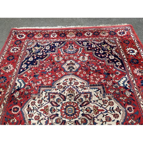 37 - Bakhtiari carpet with centre medallion and floral borders on a red ground, approximately 97ins x 134... 