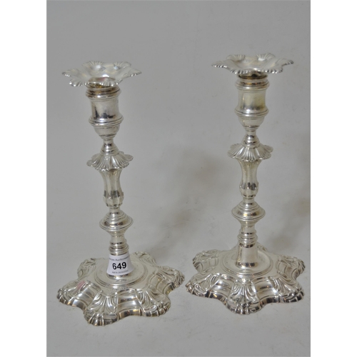 649 - Pair of George II cast silver candlesticks, the knopped stems above shaped petal form bases, London ... 