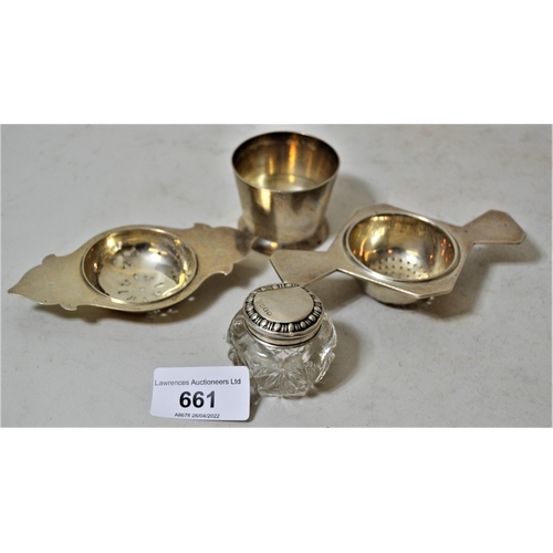 661 - Two silver tea strainers, small silver beaker and a small silver mounted glass dressing table bottle... 