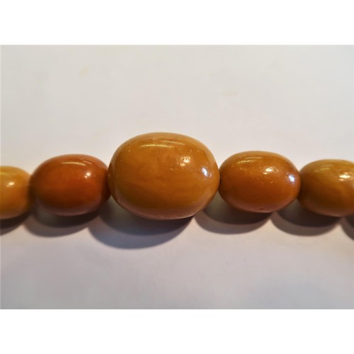 924 - Butterscotch amber bead necklace, 78g, the largest bead 29mm x 24mm diameter