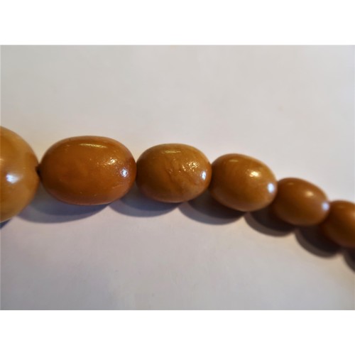 924 - Butterscotch amber bead necklace, 78g, the largest bead 29mm x 24mm diameter