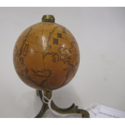 220 - 19th Century nut formed as a miniature globe,  with scrimshaw decorated surface, on a brass stand, 3... 