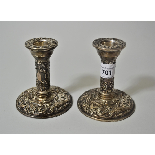 701 - Pair of small silver circular embossed candlesticks