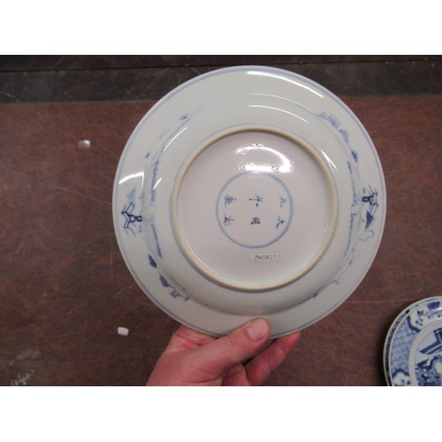 473 - Pair of modern Chinese blue and white plates decorated with figures on a terrace, six character mark... 