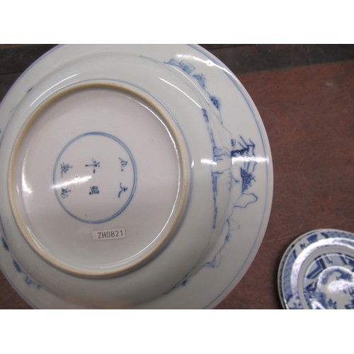 473 - Pair of modern Chinese blue and white plates decorated with figures on a terrace, six character mark... 