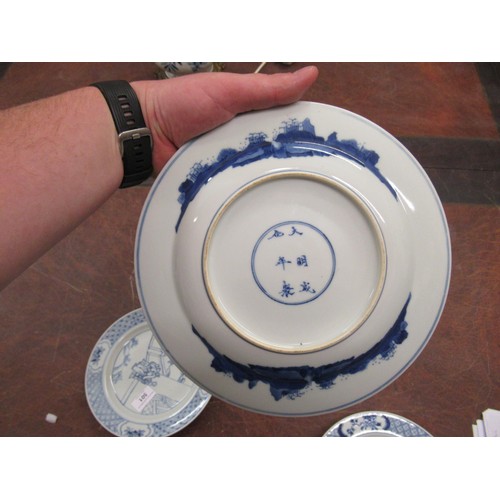 473 - Pair of modern Chinese blue and white plates decorated with figures on a terrace, six character mark... 