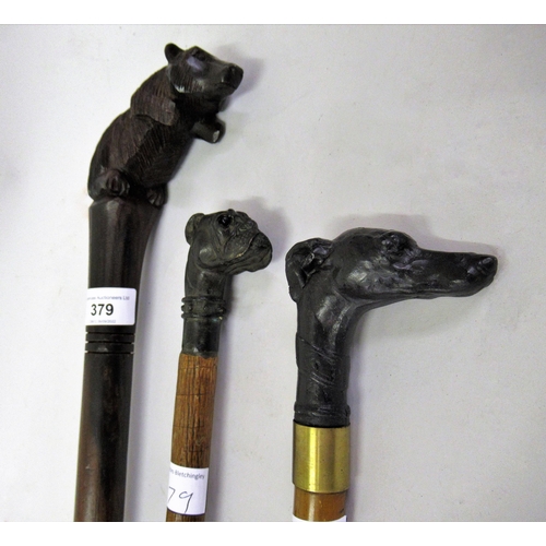 379 - Two reproduction walking sticks with dark patinated bronze dogs head handles, together with a carved... 