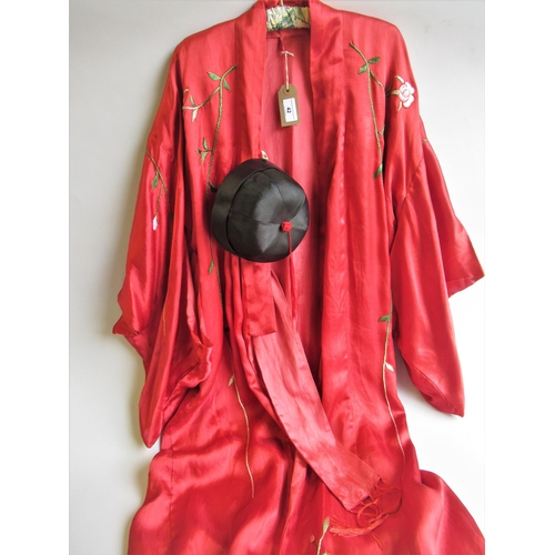 42 - Chinese red silk kimono with embroidered floral decoration, together with a hat