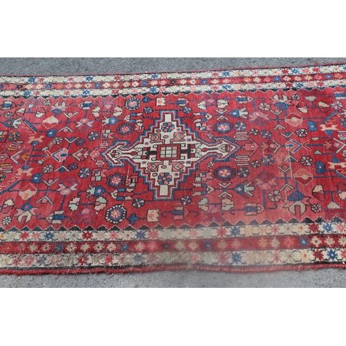 5 - Hamadan runner with a medallion and all-over stylised floral design on a red ground with borders, 14... 