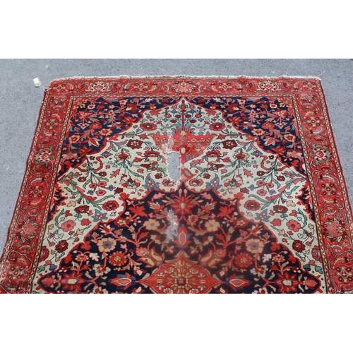 7 - Antique Baktiari rug with a medallion and all-over stylised floral design on an ivory ground, with c... 