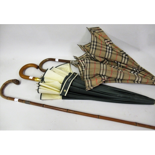 79 - Silver mounted walking cane, a small Burberry umbrella (at fault) and another umbrella