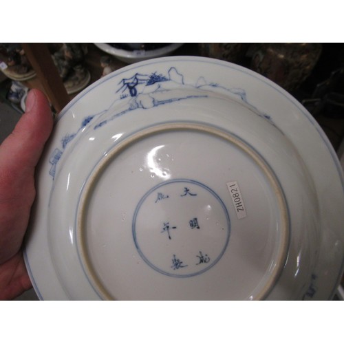 473 - Pair of modern Chinese blue and white plates decorated with figures on a terrace, six character mark... 