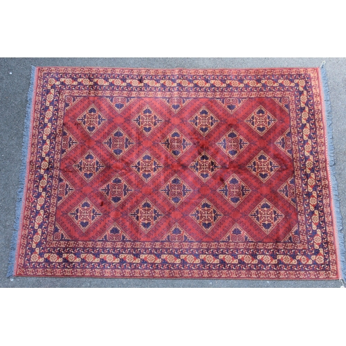 10 - Afghan carpet with an all-over hooked floral medallion design on a madder ground with multiple borde... 