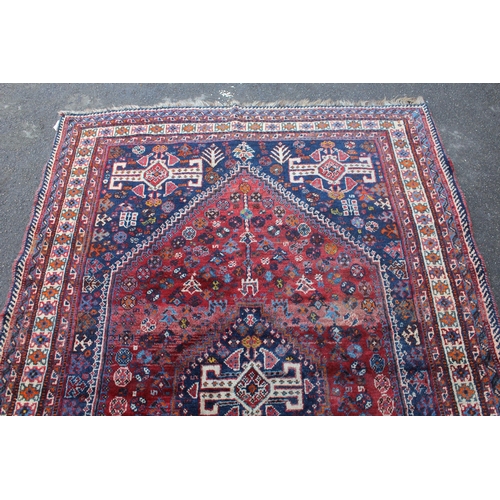 11 - Large Shiraz rug with a medallion and all-over stylised design on a red ground with blue corner desi... 