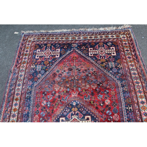 11 - Large Shiraz rug with a medallion and all-over stylised design on a red ground with blue corner desi... 