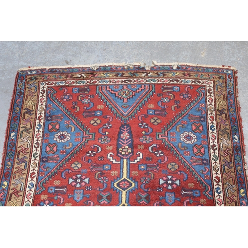 12 - Small Kurdish rug with a lobed medallion and all-over stylised floral design on a brick red field wi... 