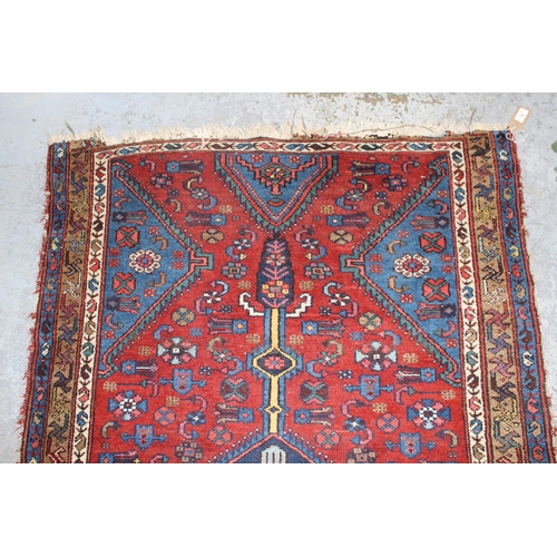 12 - Small Kurdish rug with a lobed medallion and all-over stylised floral design on a brick red field wi... 