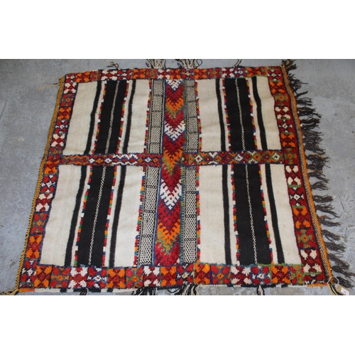 14 - Small part piled rug with a four panel design and tassel border, 4ft 8ins x 4ft 2ins approximately t... 