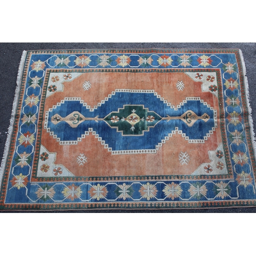 15 - Modern Turkish carpet with a central lobed medallion design on a terracotta ground with blue ground ... 