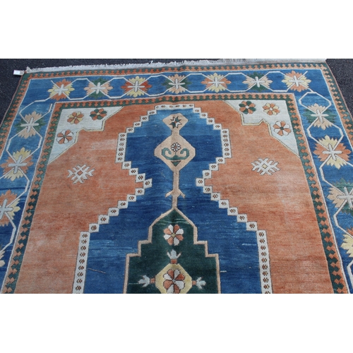 15 - Modern Turkish carpet with a central lobed medallion design on a terracotta ground with blue ground ... 