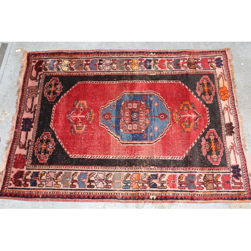 18 - Small south west Persian rug with a medallion and floral design on a red ground with borders, 4ft 10... 