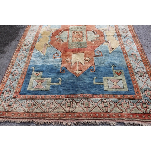 19 - Modern Turkish carpet with a central hooked medallion design on a blue and terracotta ground with bo... 