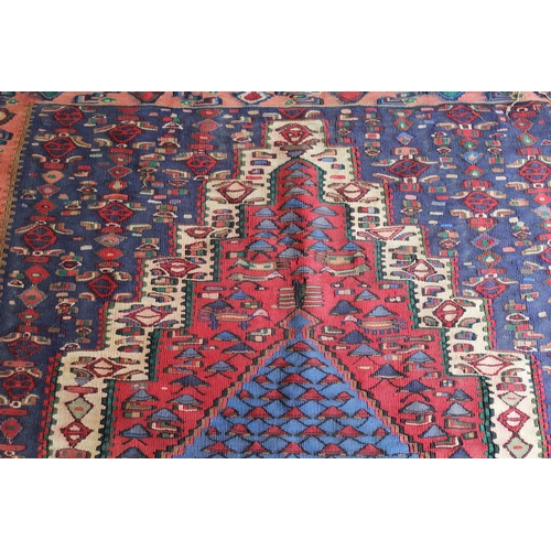 29 - Senneh Kelim rug with a medallion and all-over stylised design in shades of red, blue and cream, 4ft... 