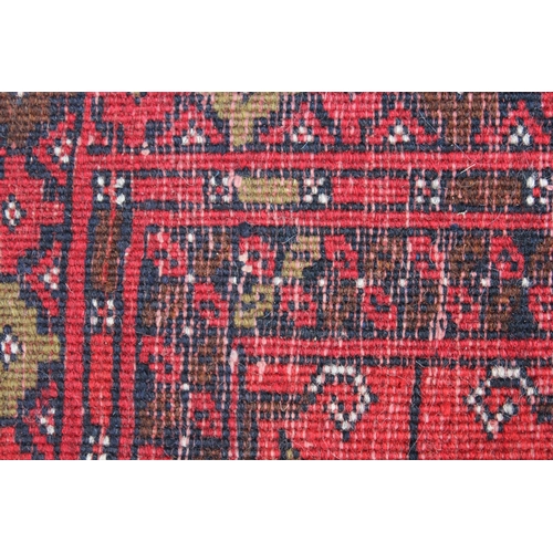 33 - Afghan runner with repeating gol design on a red ground with borders, 9ft 8ins x 2ft 10ins approxima... 