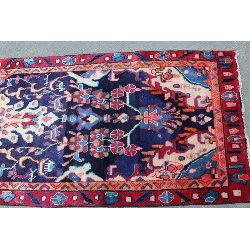 34 - Sarouk runner with a medallion and floral design on a blue ground with borders, 8ft 2ins x 2ft 10ins... 