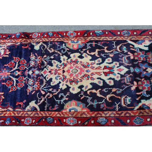 34 - Sarouk runner with a medallion and floral design on a blue ground with borders, 8ft 2ins x 2ft 10ins... 