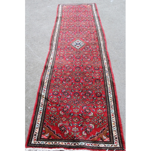 35 - Hamadan runner with a medallion and all-over Herati design on a red ground with borders, 9ft 8ins x ... 