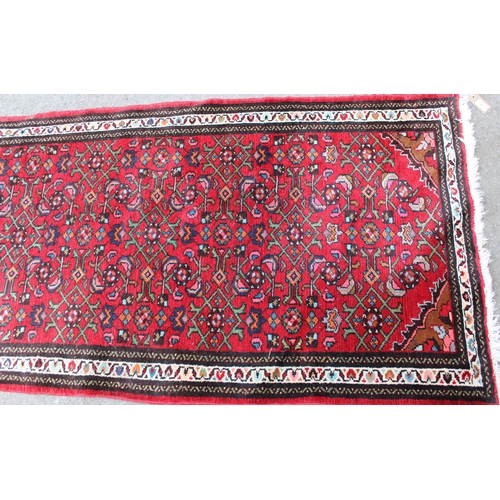 35 - Hamadan runner with a medallion and all-over Herati design on a red ground with borders, 9ft 8ins x ... 