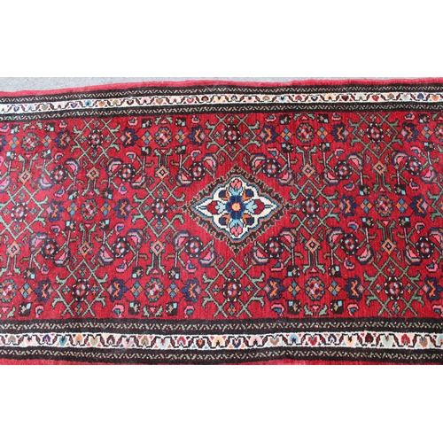 35 - Hamadan runner with a medallion and all-over Herati design on a red ground with borders, 9ft 8ins x ... 