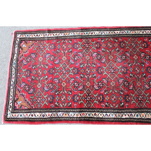 35 - Hamadan runner with a medallion and all-over Herati design on a red ground with borders, 9ft 8ins x ... 