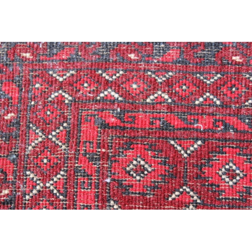 38 - Afghan rug with three rows of eleven gols, with multiple borders on a wine ground, 79ins x 59ins