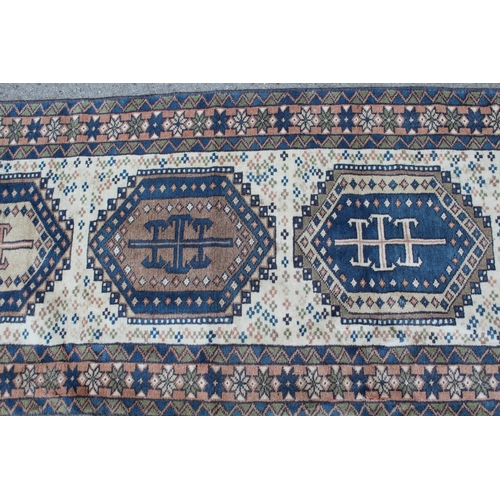 41 - Modern Turkish runner with six medallions on a cream ground with borders, 9ft 4ins x 2ft 6ins approx... 