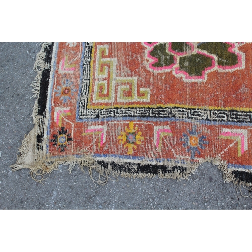 45 - Small Tibetan rug with a triple medallion and polychrome design, 5ft 6ins x 2ft 10ins approximately ... 