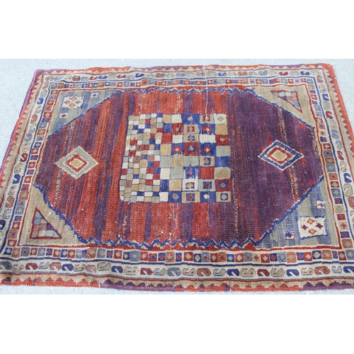 45 - Small Tibetan rug with a triple medallion and polychrome design, 5ft 6ins x 2ft 10ins approximately ... 