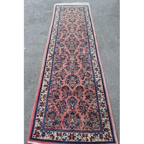 47 - Sarouk runner with a medallion and all-over floral design on a rose ground with borders, 10ft x 2ft ... 