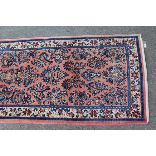 47 - Sarouk runner with a medallion and all-over floral design on a rose ground with borders, 10ft x 2ft ... 