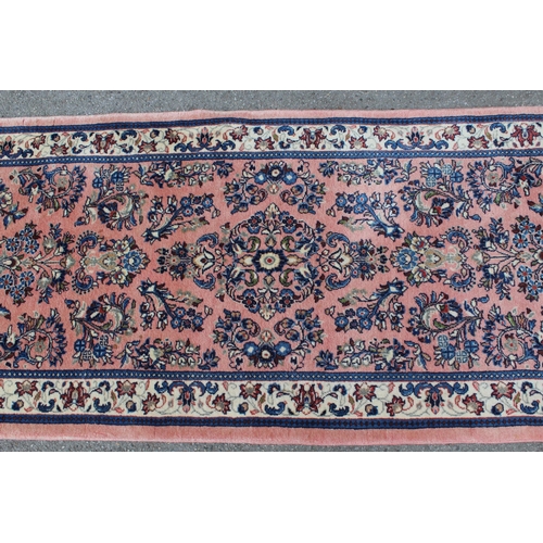 47 - Sarouk runner with a medallion and all-over floral design on a rose ground with borders, 10ft x 2ft ... 