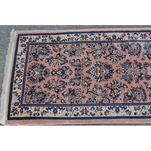 47 - Sarouk runner with a medallion and all-over floral design on a rose ground with borders, 10ft x 2ft ... 